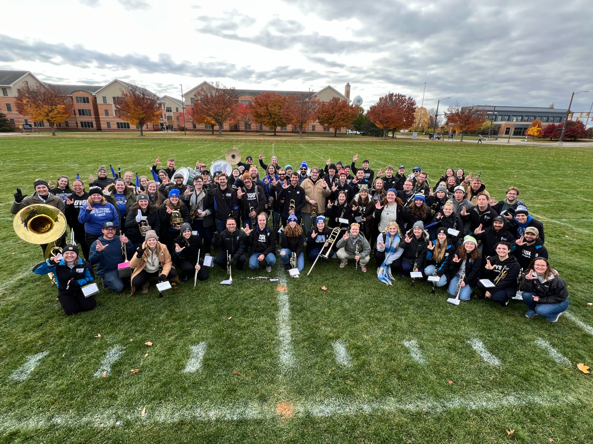laker alumni marching band on the practice field in an arch for a group photo for 2025 homecoming